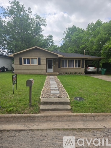 A house with a grey car in front of it.