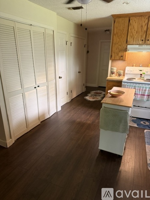 A kitchen with wooden cabinets and a white stove top oven.