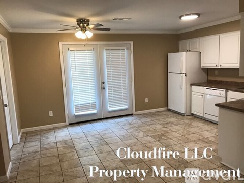 A kitchen with a tile floor and a ceiling fan.