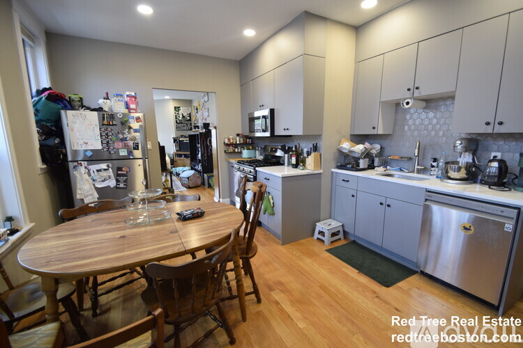 A kitchen with a table and chairs in the middle of the room.