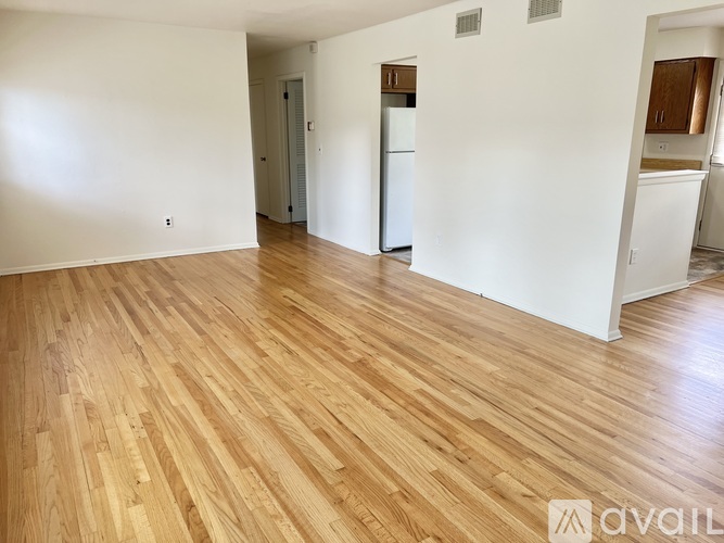 A room with wooden flooring and white walls.