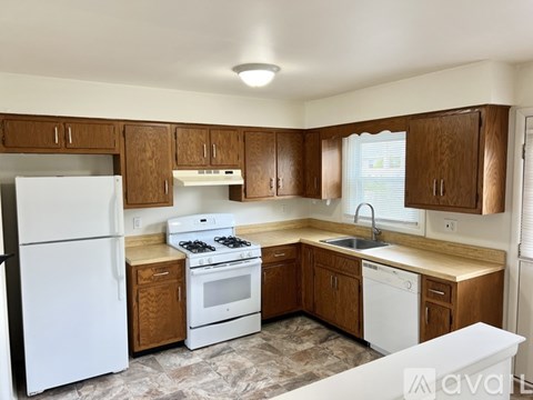 A kitchen with wooden cabinets and white appliances.