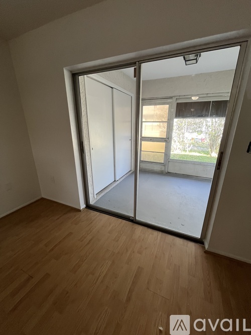 A room with a sliding glass door leading to a balcony.