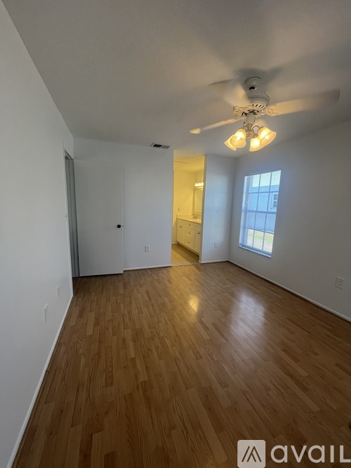 A room with wooden flooring and a ceiling fan.