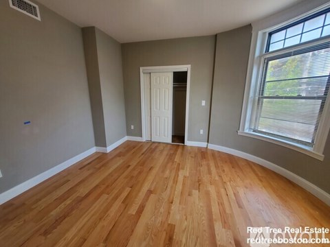 A room with wooden flooring and a white door.