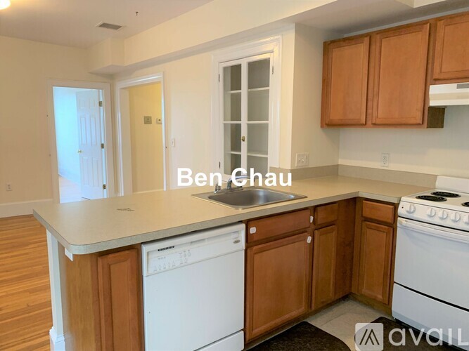 A kitchen with wooden cabinets and a white dishwasher.