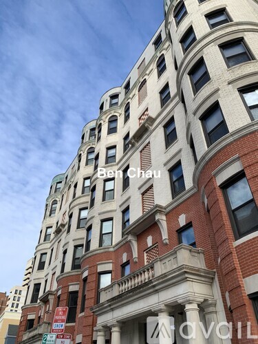 A tall building with a balcony on the second floor from the front.