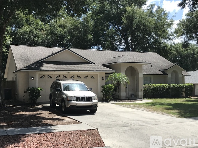 A white car is parked in front of a house.