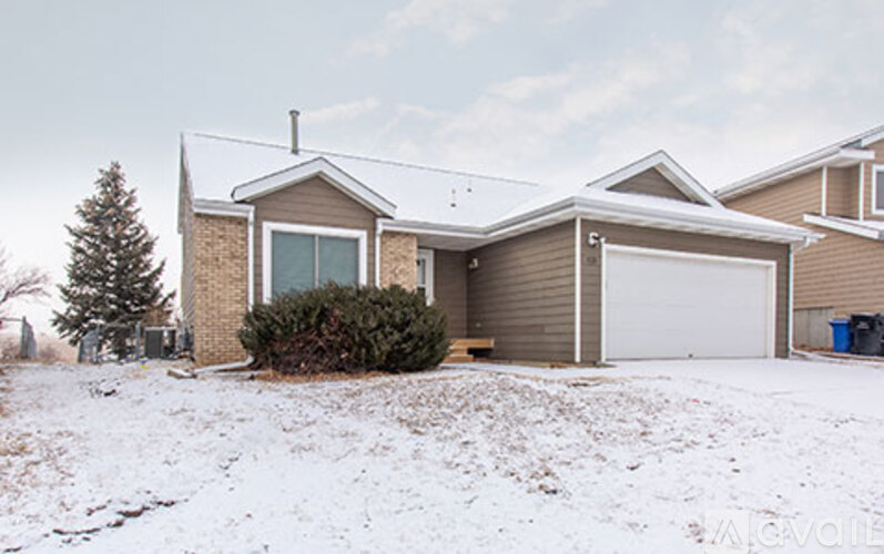 A house with a garage and a driveway covered in snow.