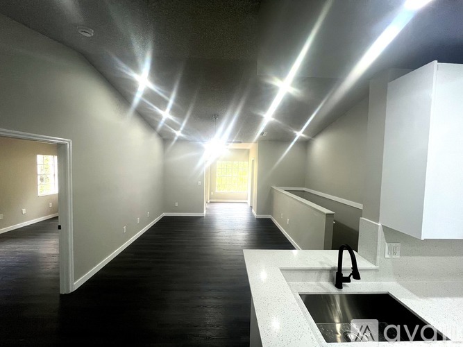 A long hallway with a sink and lights on the ceiling.