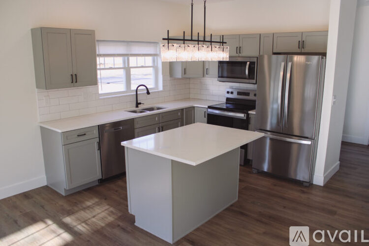 A kitchen with a white island and stainless steel appliances.