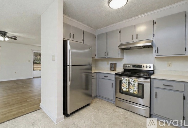 A kitchen with a stainless steel refrigerator, oven, and cabinets.