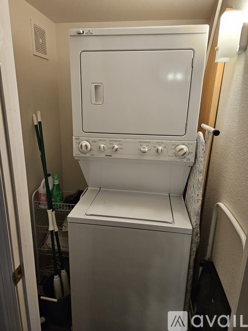 A small white dishwasher is in a narrow space.