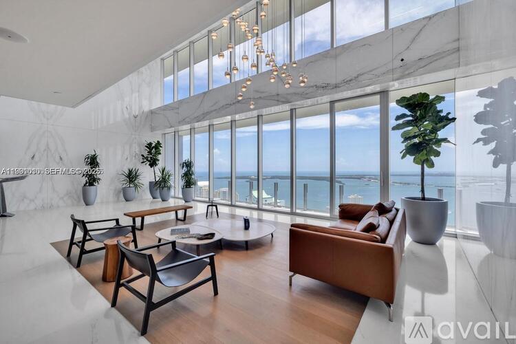 A living room with a large window overlooking the ocean.