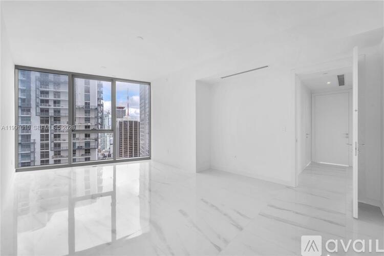 A white room with a large window and a door.