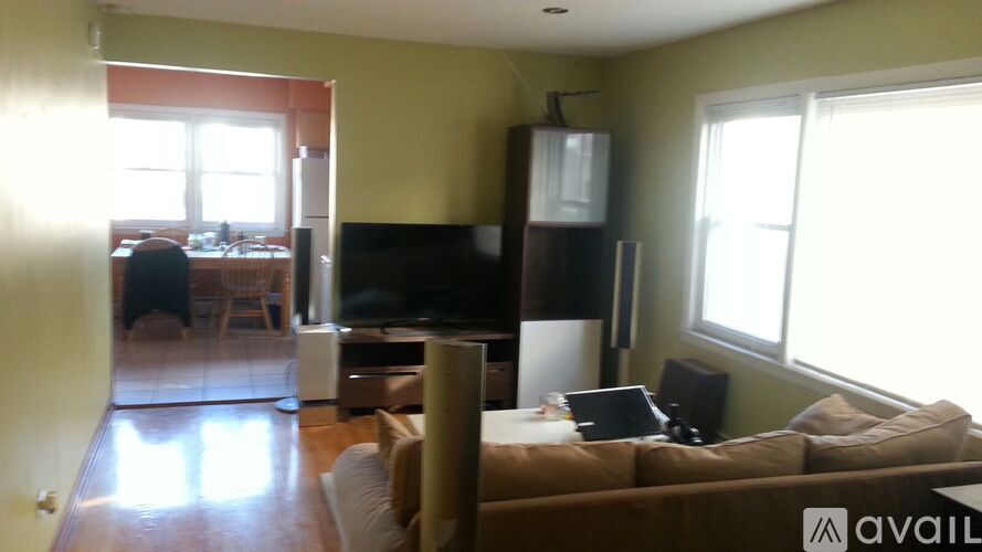 A living room with a couch, television, and a window.