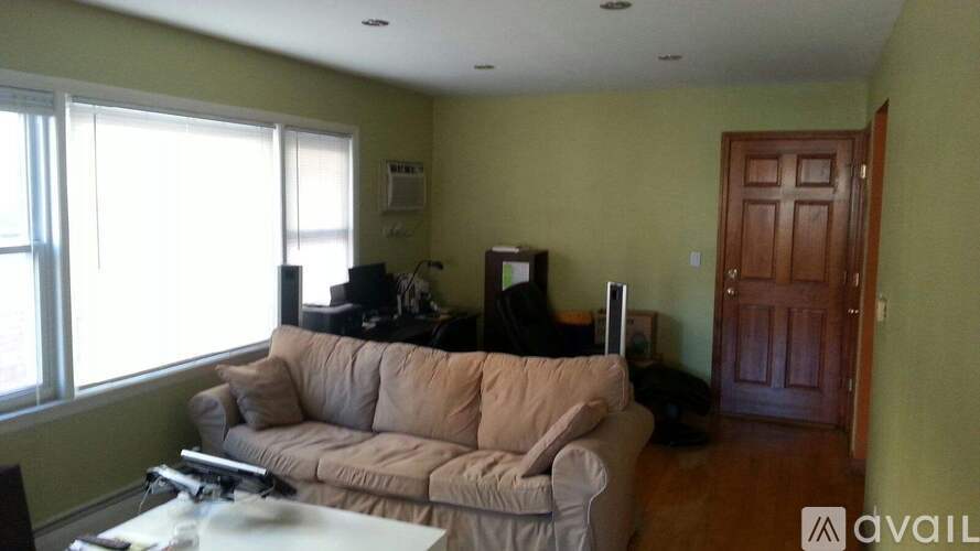 A living room with a couch, a coffee table, and a television.