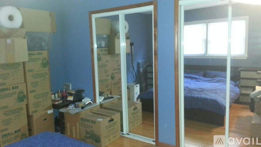A room with boxes and a bed in the background.