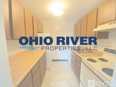 A kitchen with wooden cabinets and a logo that reads "Ohio River Properties LLC".