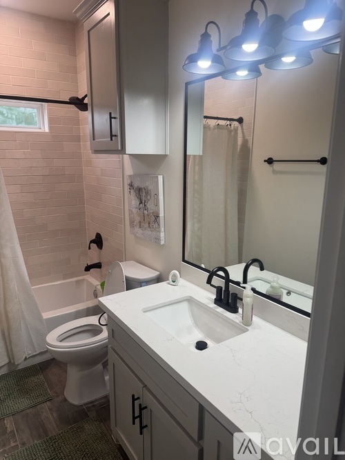 A bathroom with a white sink and a toilet.