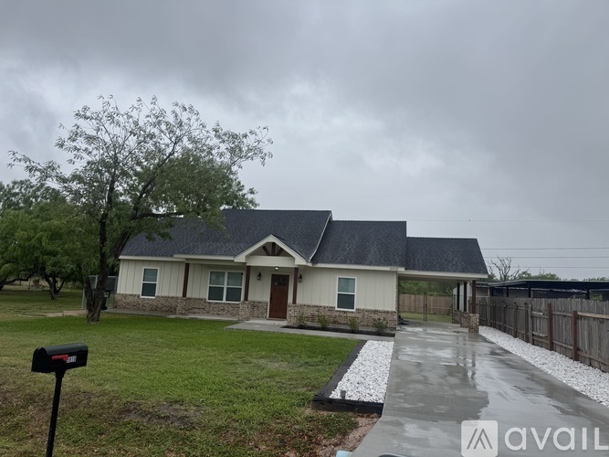 A house with a grey roof and a white fence.