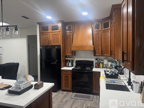 A kitchen with wooden cabinets and black appliances.