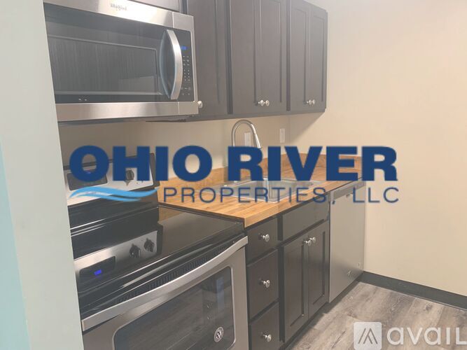 A kitchen with a stainless steel microwave and oven, and cabinets with a logo that reads "OHIO RIVER PROPERTIES, LLC".
