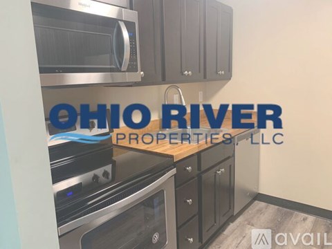 A kitchen with a stainless steel microwave and oven, and cabinets with a logo that reads "OHIO RIVER PROPERTIES, LLC".