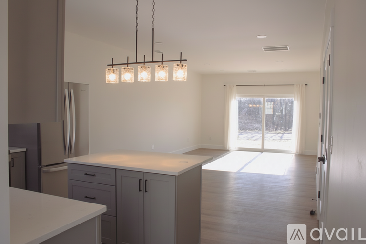 A kitchen with a white counter top and cabinets.