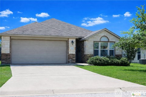 A house with a garage door and a driveway.