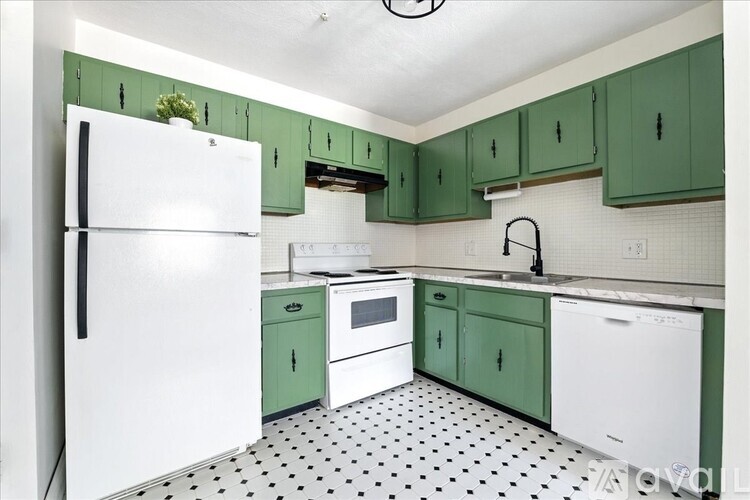A kitchen with green cabinets and a white fridge.
