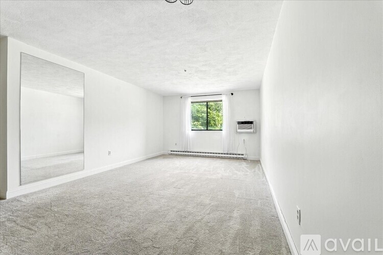 A spacious empty room with a window and a door.