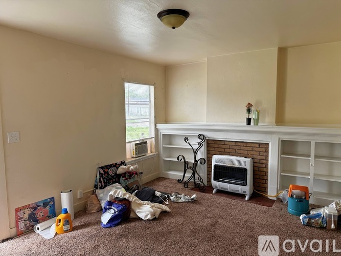 A room with a fireplace and a carpet on the floor.