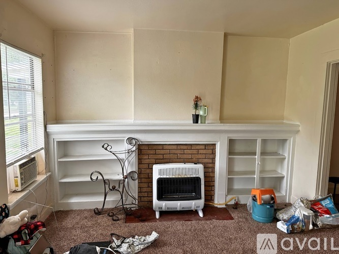 A room with a fireplace and a shelf is being set up for a photo shoot.