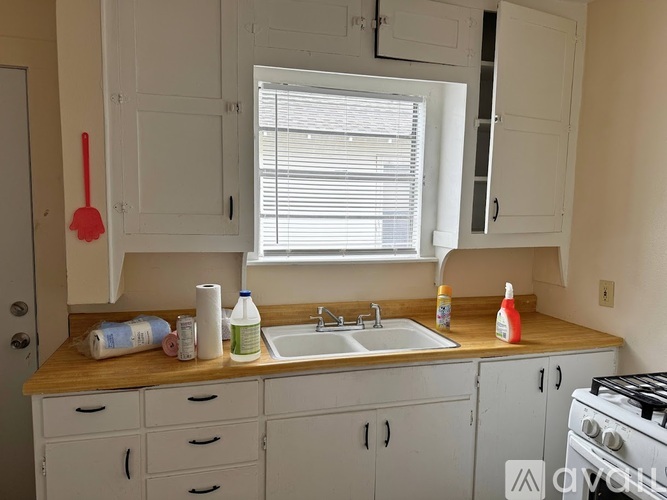 A kitchen with white cabinets and a wooden countertop.