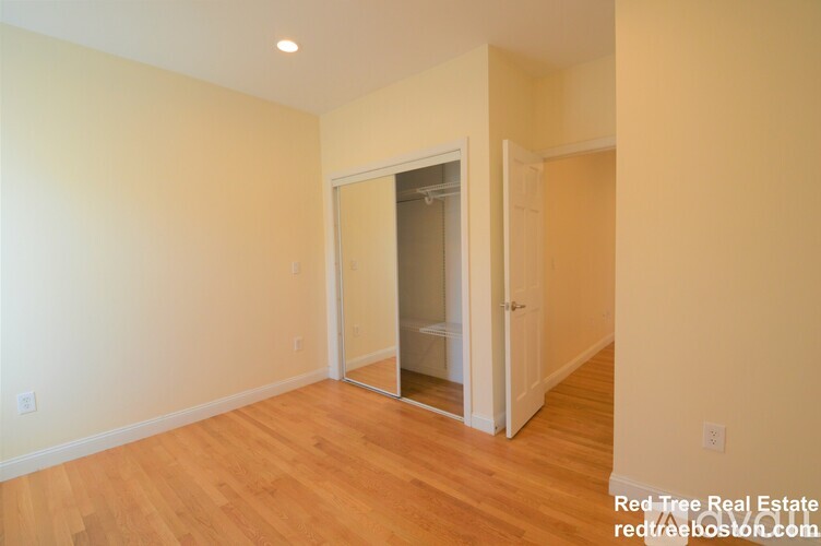 A room with a white wall and a wooden floor.