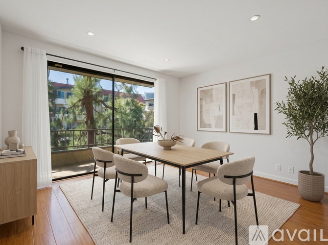 A dining room with a table and chairs and a potted plant.