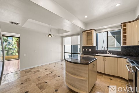 A kitchen with wooden cabinets and a black countertop is available for rent.