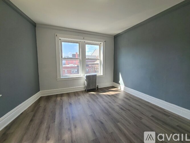 A room with a window and a radiator on the floor.