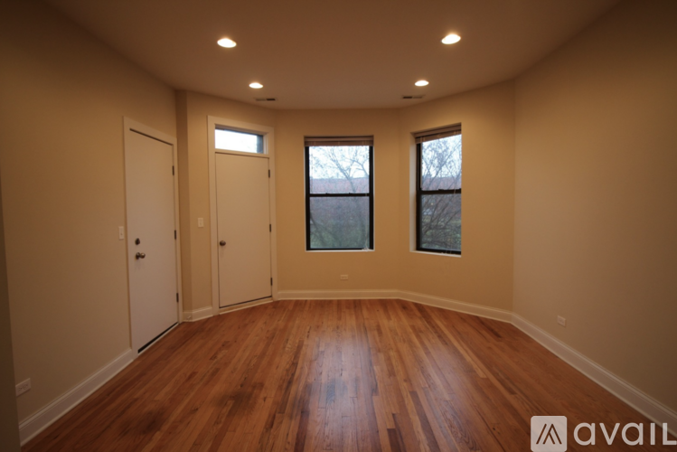 A room with wooden floors and two windows.