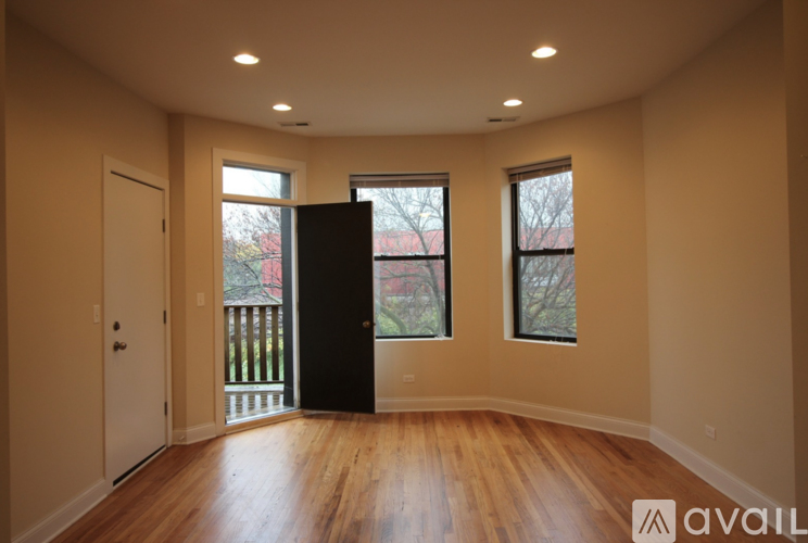 A room with wooden floors and a black door.