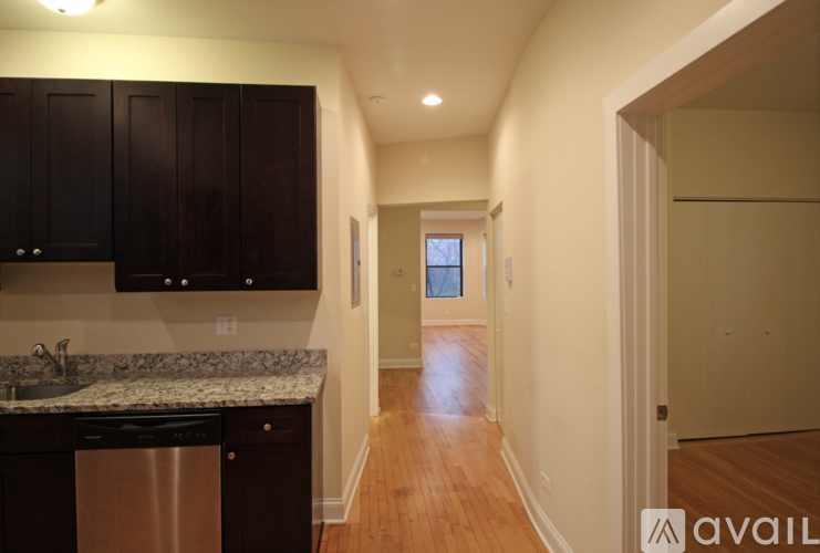 A kitchen with dark brown cabinets and a granite countertop.