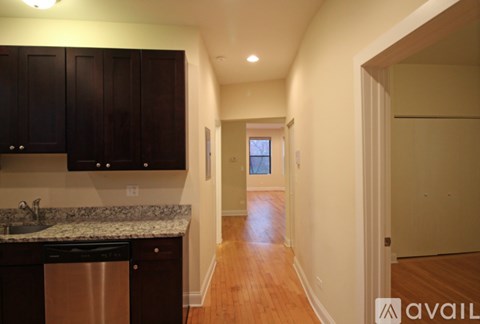 A kitchen with dark brown cabinets and a granite countertop.