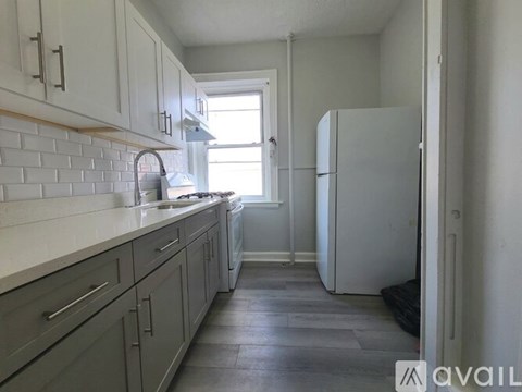 A kitchen with a white fridge and a window.