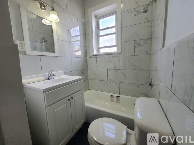A bathroom with a white toilet, sink, and bathtub.