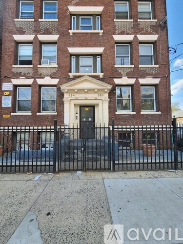 A brick building with a black gate in front.