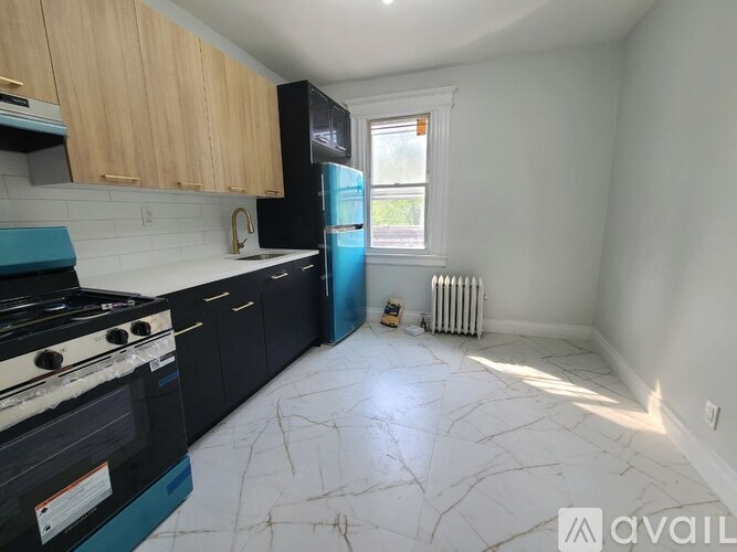 A kitchen with black appliances and wooden cabinets.