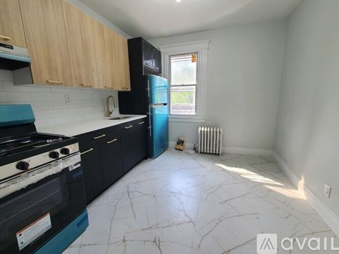 A kitchen with black appliances and wooden cabinets.