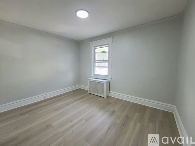 A room with a window and a radiator on the wall.