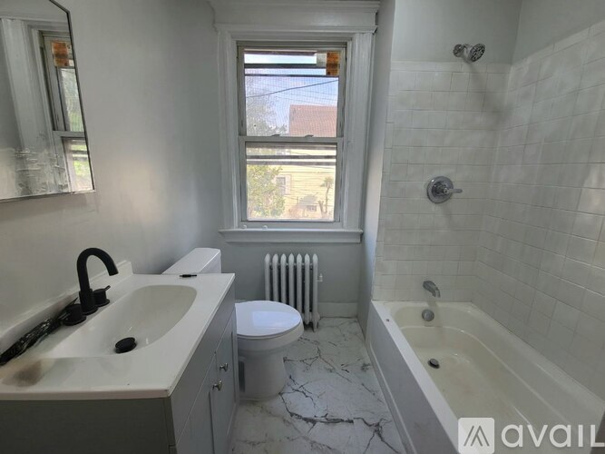A bathroom with a white toilet, sink, and bathtub.